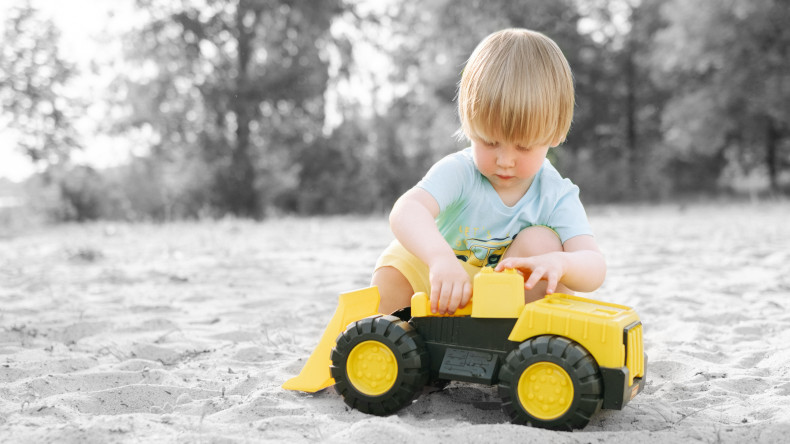 Enfant qui s'amuse avec un jouet tracteur en plastique